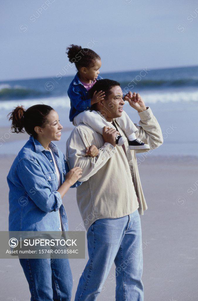 Stock Photo: 1574R-0018584C Parents smiling with their daughter on the beach