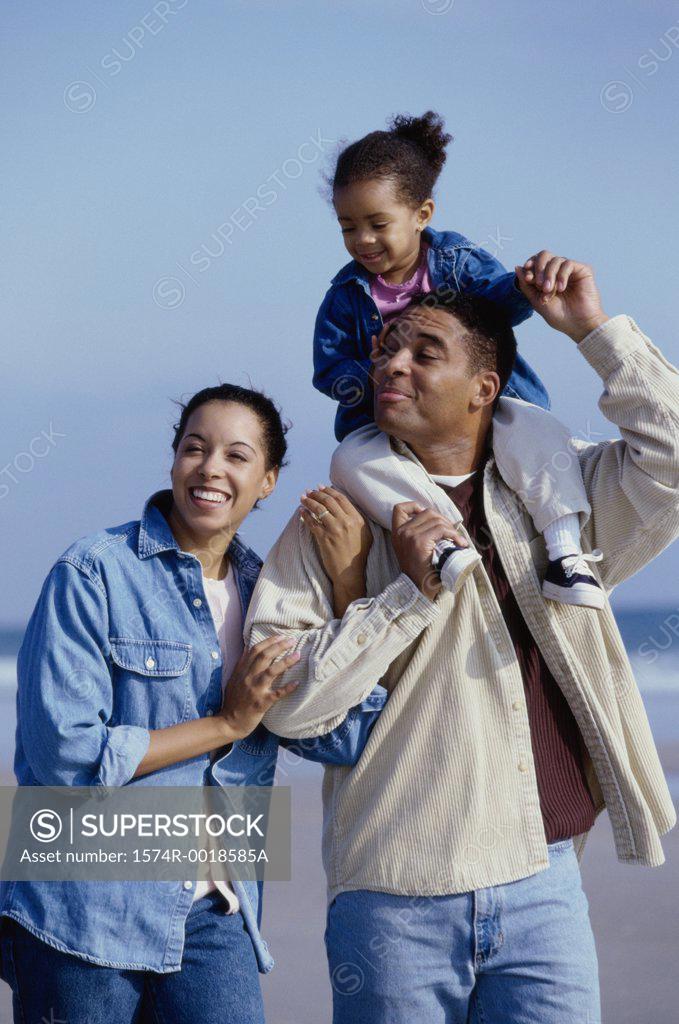 Stock Photo: 1574R-0018585A Parents and their daughter smiling on the beach
