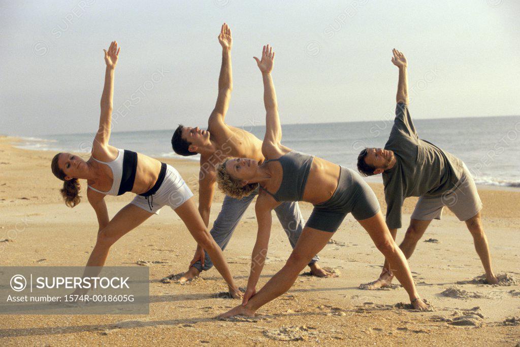 Stock Photo: 1574R-0018605G Group of people performing yoga on the beach