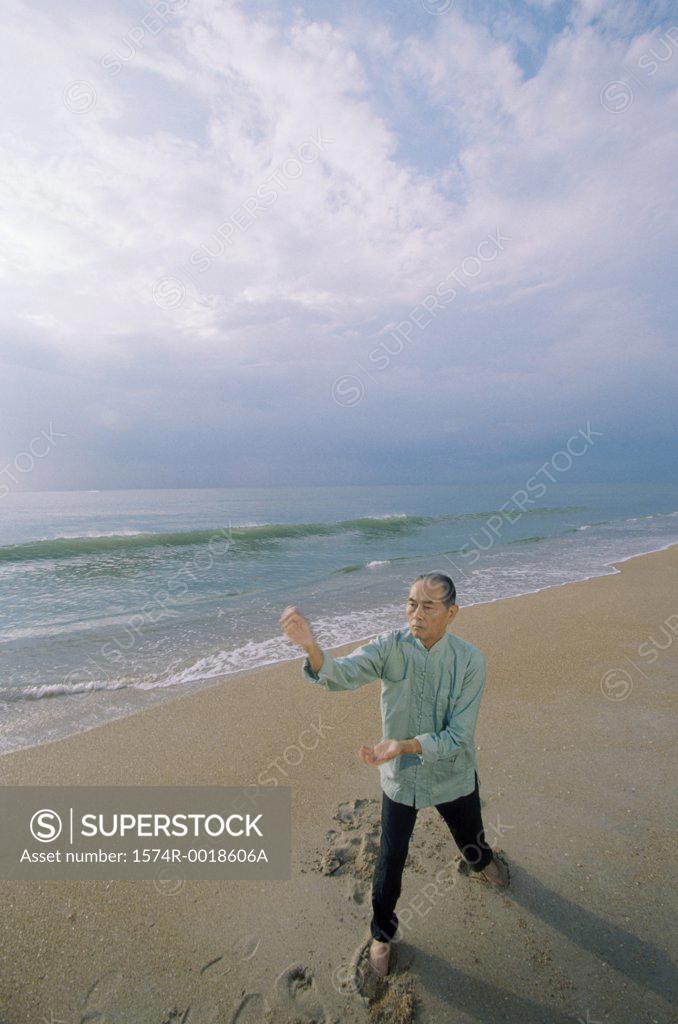 Stock Photo: 1574R-0018606A High angle view of a senior man practicing tai chi on the beach