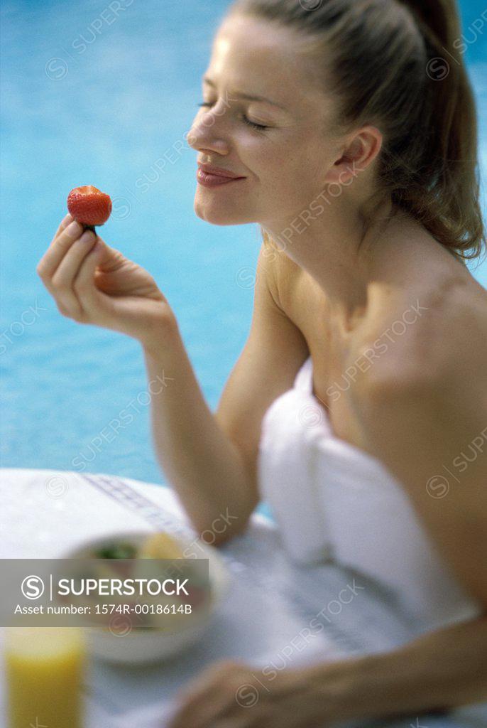 Stock Photo: 1574R-0018614B Close-up of a young woman holding a strawberry