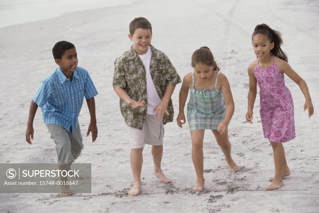 Stock Photo: 1574R-0018647 Two boys and two girls preparing for a race on the beach
