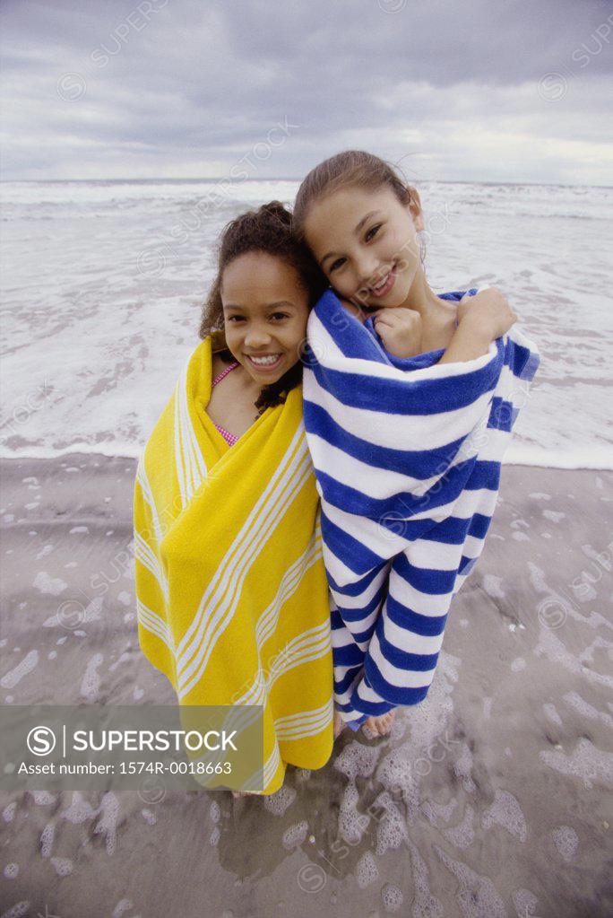 Stock Photo: 1574R-0018663 Portrait of two girls wrapped in towels on the beach