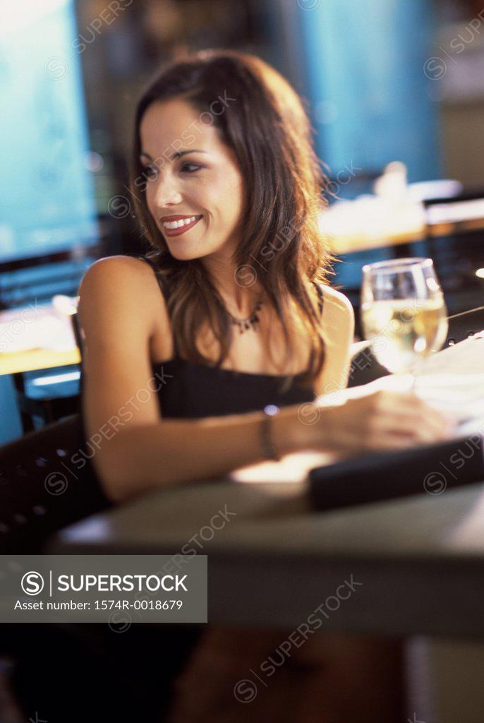 Stock Photo: 1574R-0018679 Young woman with a glass of white wine in front of her