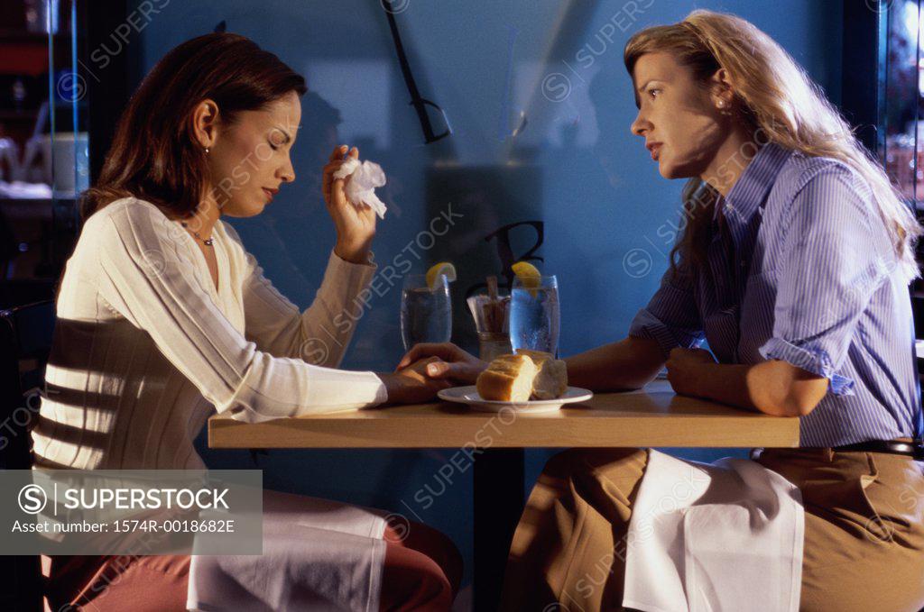 Stock Photo: 1574R-0018682E Two young women sitting together talking