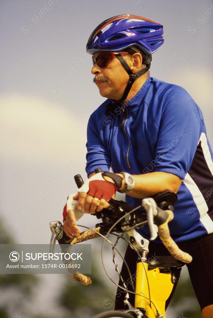Stock Photo: 1574R-0018692 Mid adult man standing with a bicycle