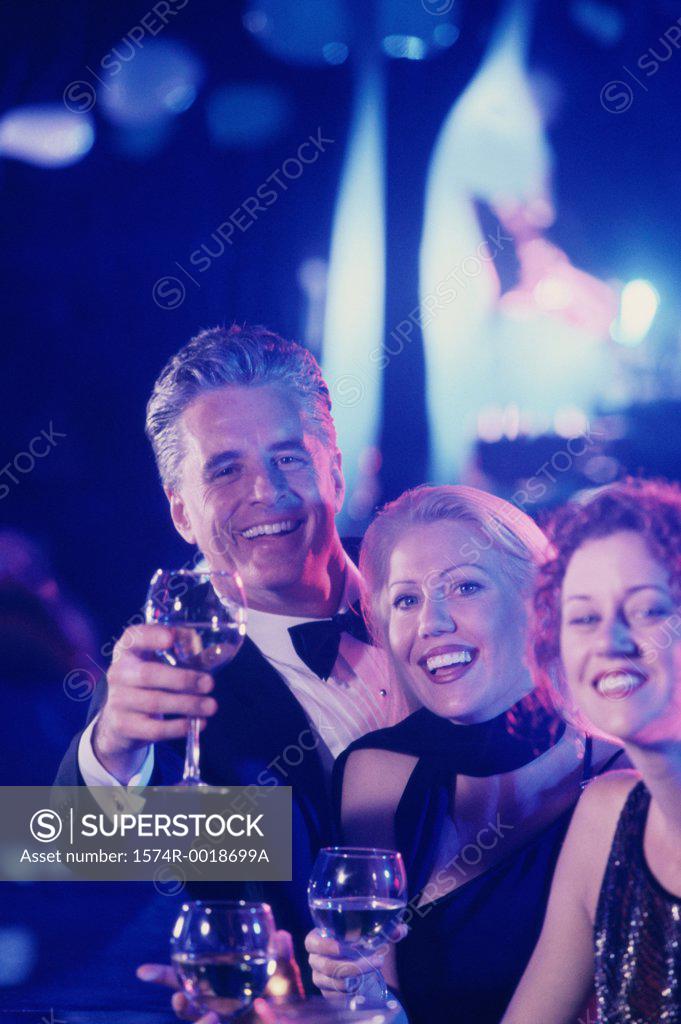 Stock Photo: 1574R-0018699A Portrait of two mature women and a mature man toasting with wineglasses