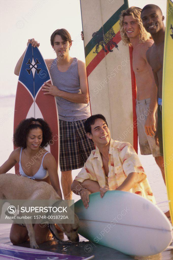 Stock Photo: 1574R-0018720A Four young men and a young woman with surfboards on the beach