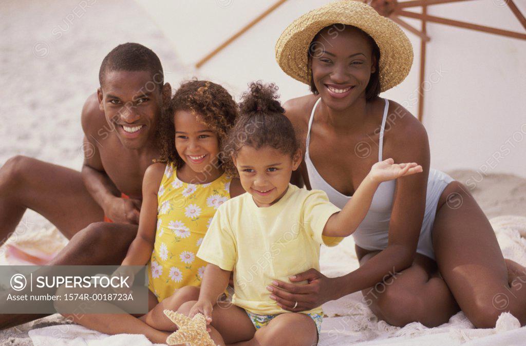 Stock Photo: 1574R-0018723A Portrait of parents and their two daughters smiling on the beach