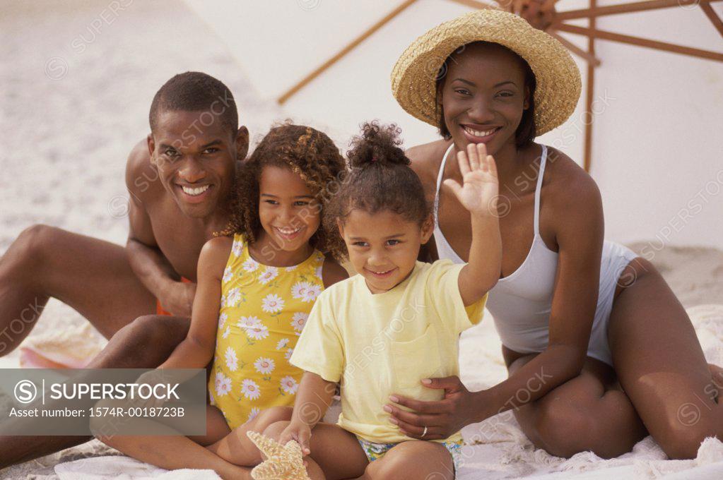 Stock Photo: 1574R-0018723B Portrait of parents and their two daughters smiling on the beach