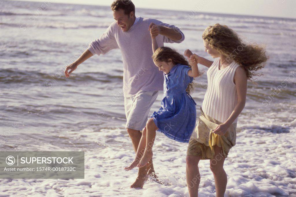Stock Photo: 1574R-0018732C Parents and their daughter walking on the beach