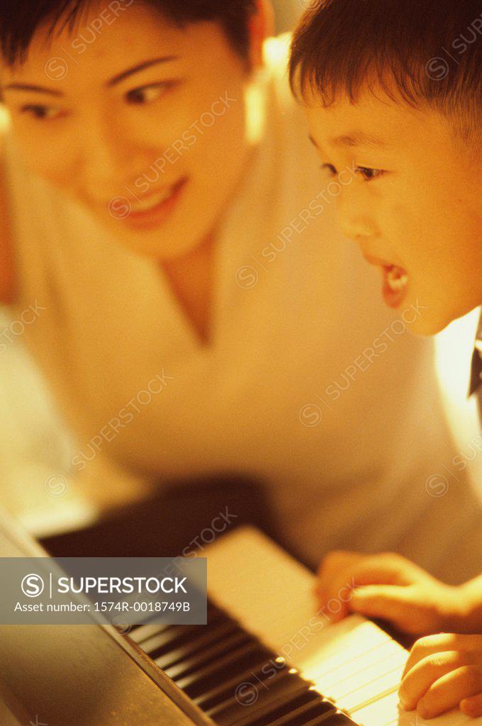 Stock Photo: 1574R-0018749B Mother teaching her son to play the piano