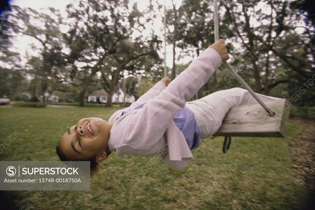 Stock Photo: 1574R-0018750A Girl swinging on a swing