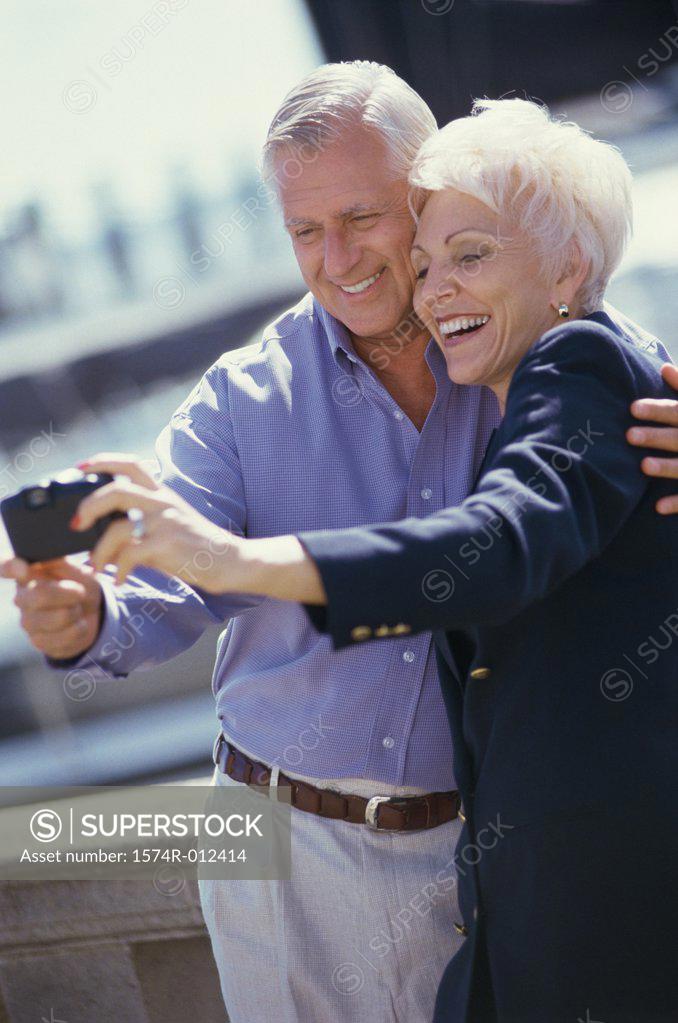 Stock Photo: 1574R-012414 Senior couple taking a photograph of themselves