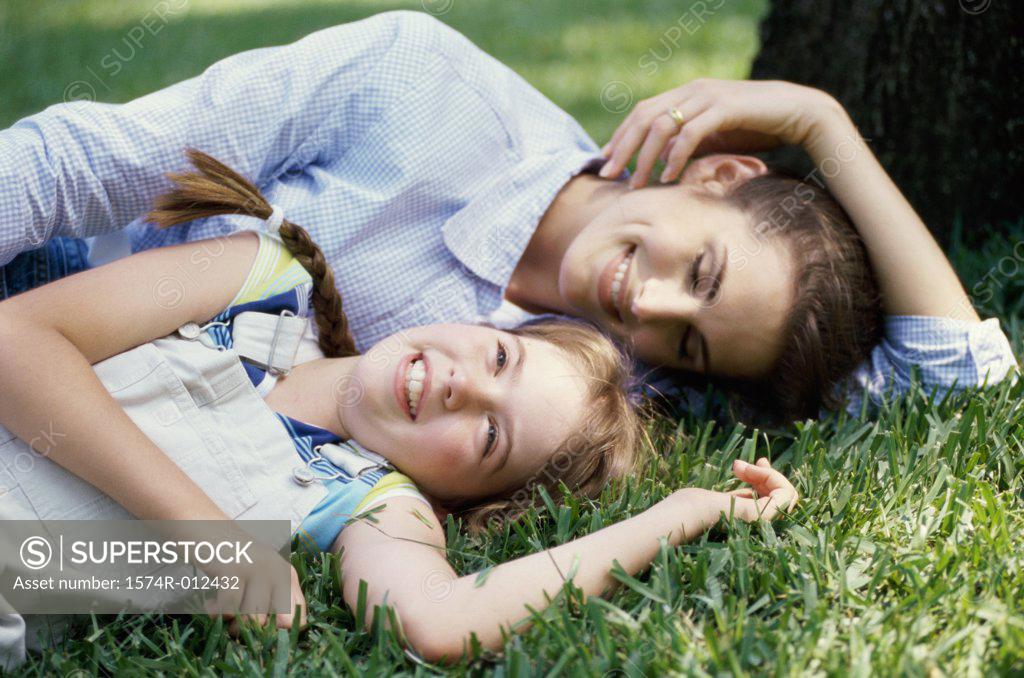 Stock Photo: 1574R-012432 Close-up of a mother and daughter lying in the grass in a park