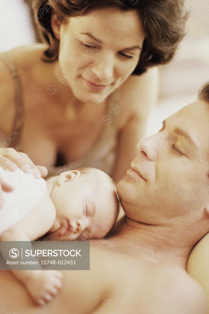 Stock Photo: 1574R-012451 Close-up of a son sleeping on the chest of his father while her mother looking at him