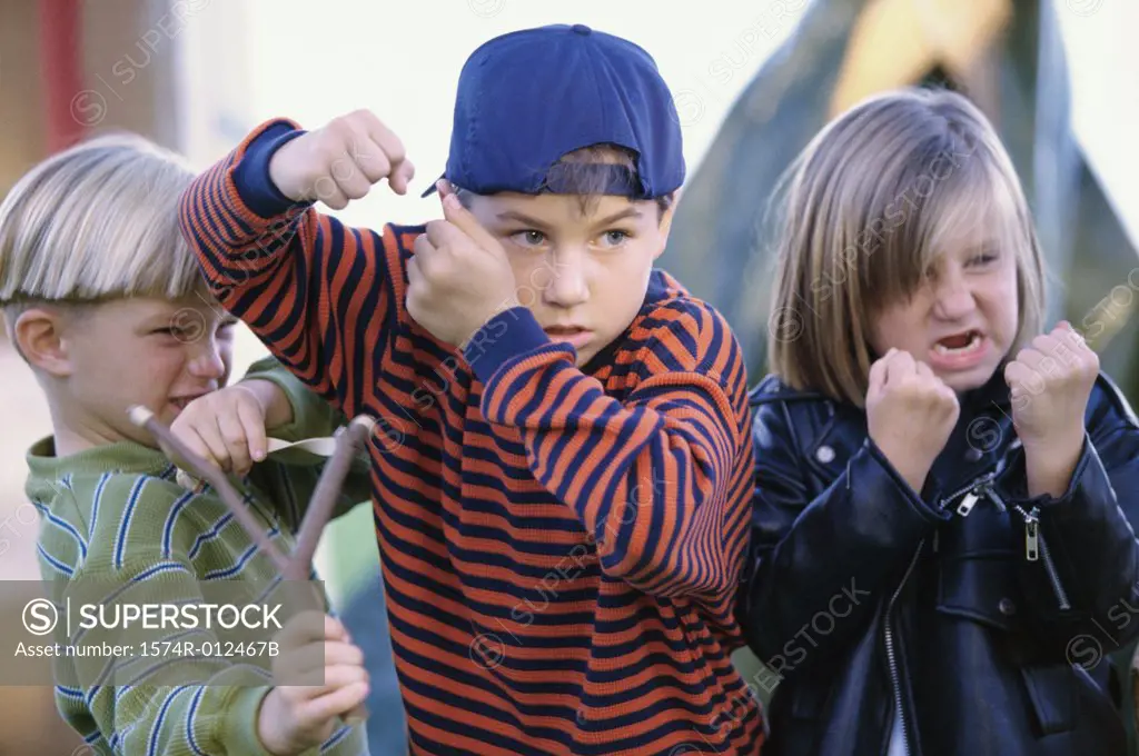 Girl and two boys showing their fists in anger
