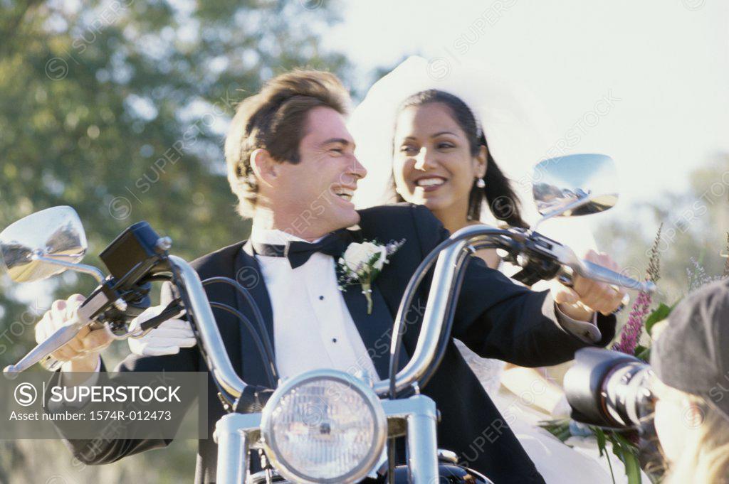 Stock Photo: 1574R-012473 Low angle view of a newlywed couple riding a motorcycle