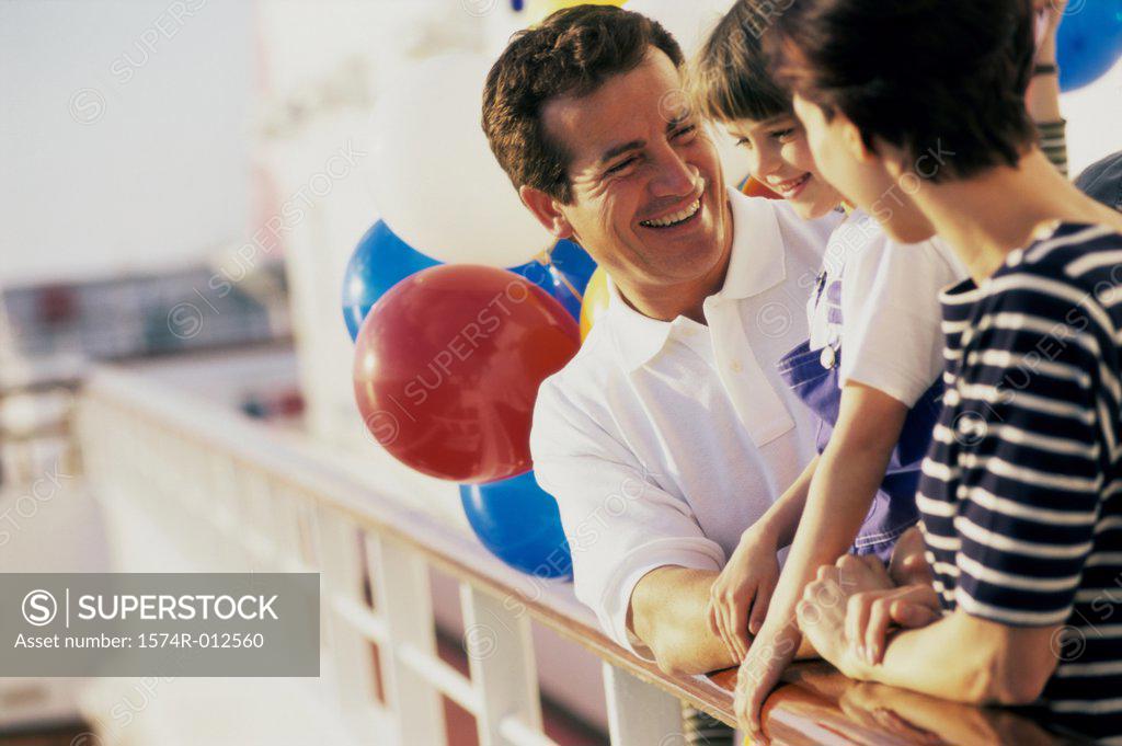 Stock Photo: 1574R-012560 Close-up of parents standing with their daughter on a cruise ship