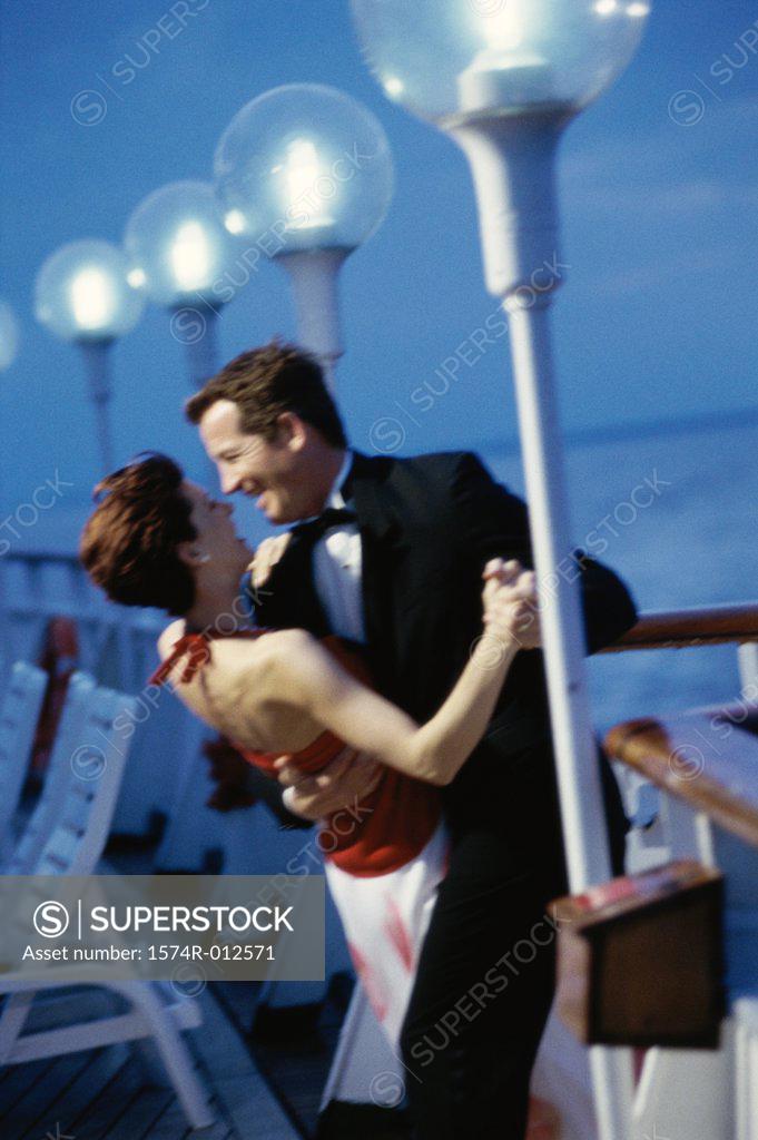 Stock Photo: 1574R-012571 Side profile of a young couple dancing on the deck of a cruise ship