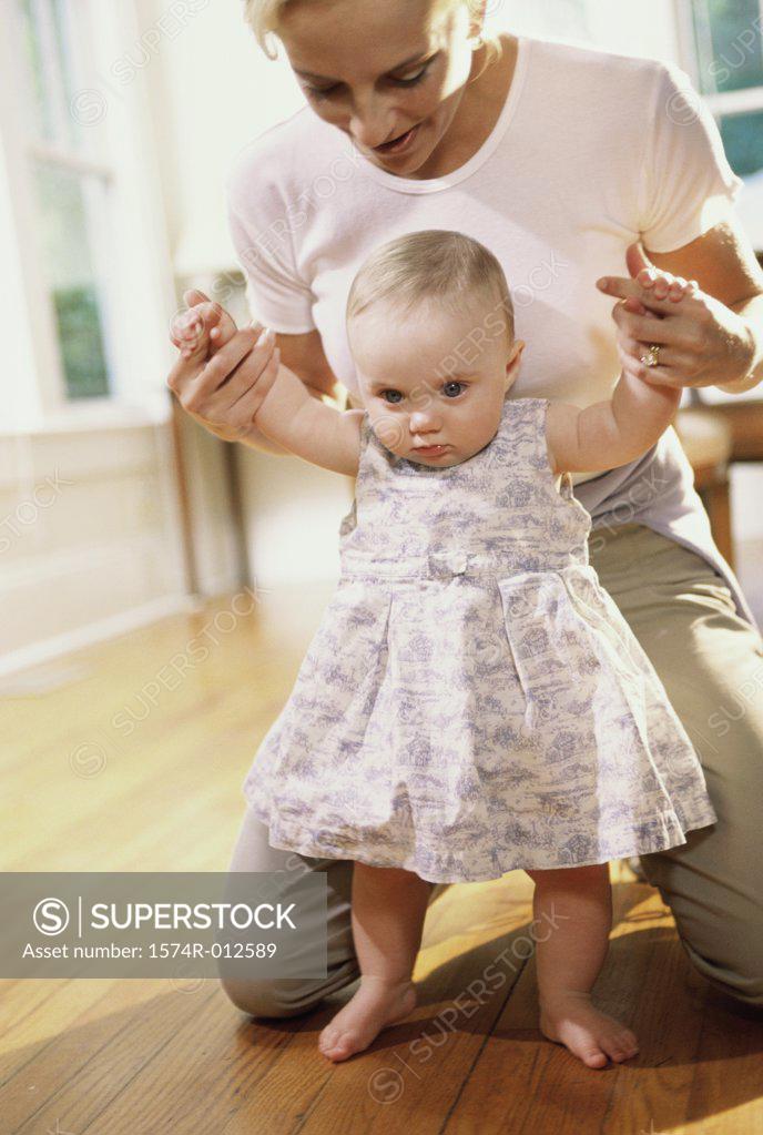 Stock Photo: 1574R-012589 Close-up of a mother teaching her daughter to walk