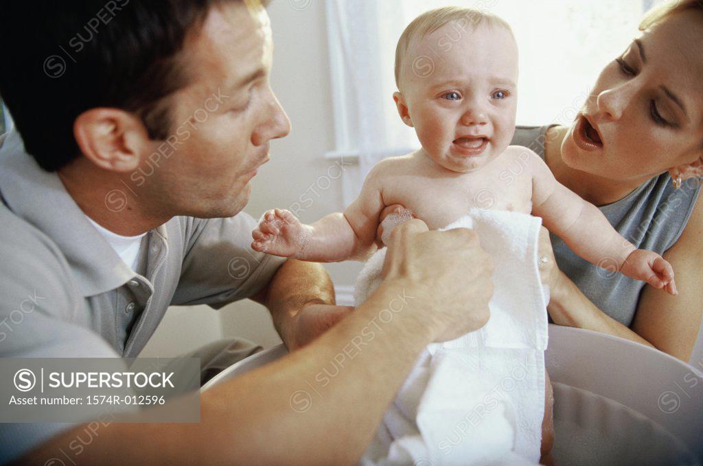 Stock Photo: 1574R-012596 Close-up of parents giving their son a bath