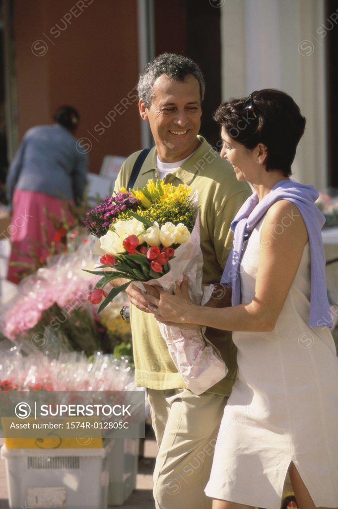 Stock Photo: 1574R-012805C Side profile of a mid adult couple holding a bouquet of flowers