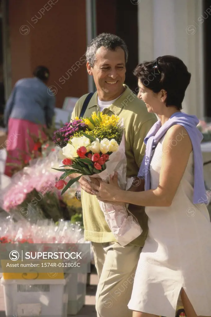 Side profile of a mid adult couple holding a bouquet of flowers