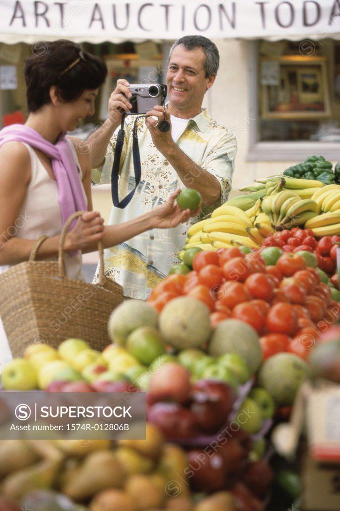Stock Photo: 1574R-012806B Mid adult man taking a photograph of a mid adult woman