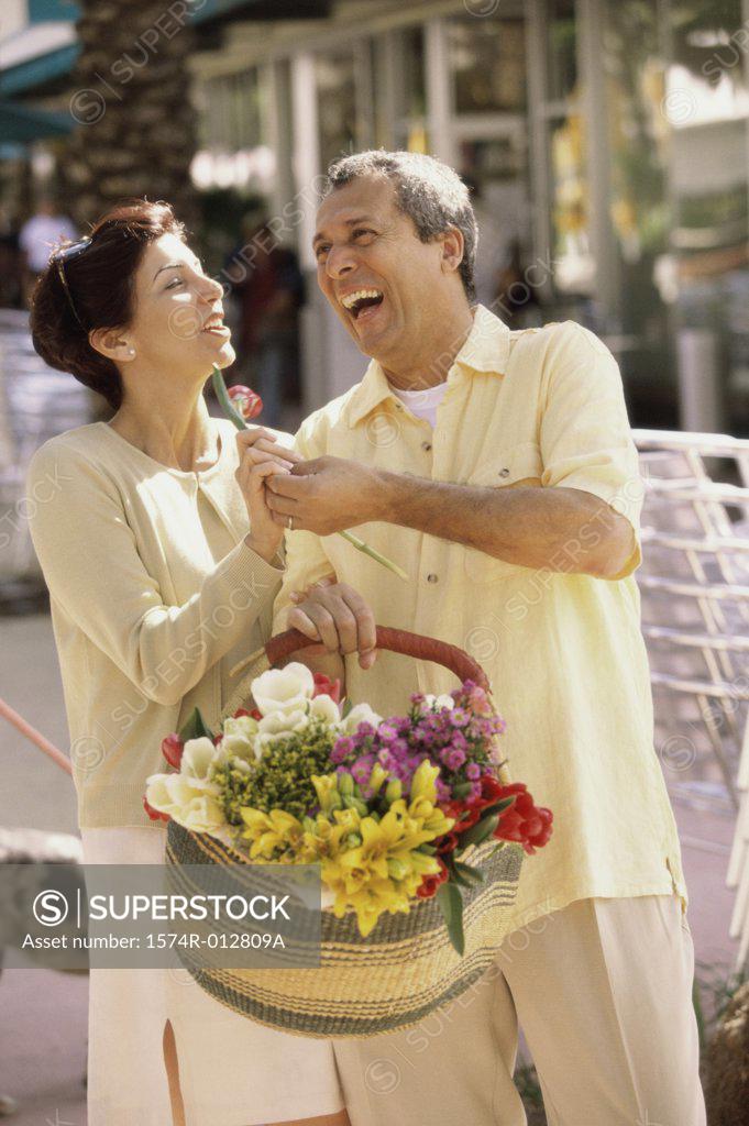 Stock Photo: 1574R-012809A Mature man giving a flower to a mature woman