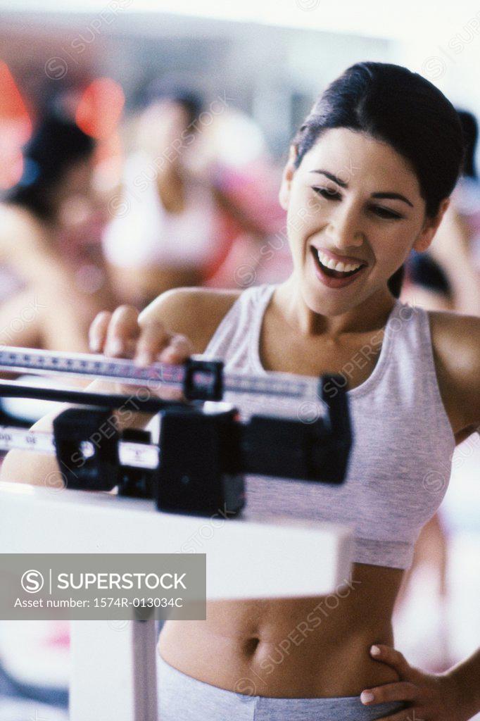 Stock Photo: 1574R-013034C Young woman standing on a weight scale