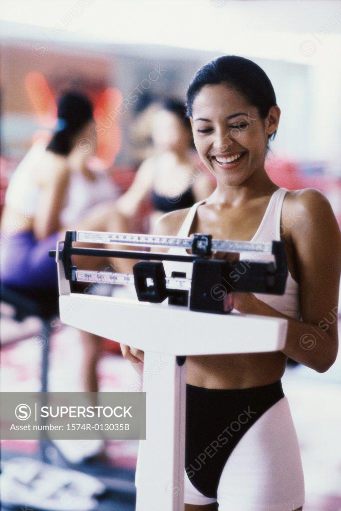 Stock Photo: 1574R-013035B Young woman standing on a weight scale