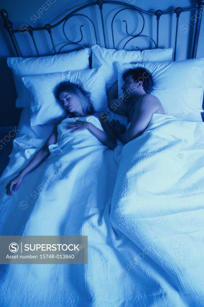 Stock Photo: 1574R-013860 High angle view of a young couple sleeping in bed