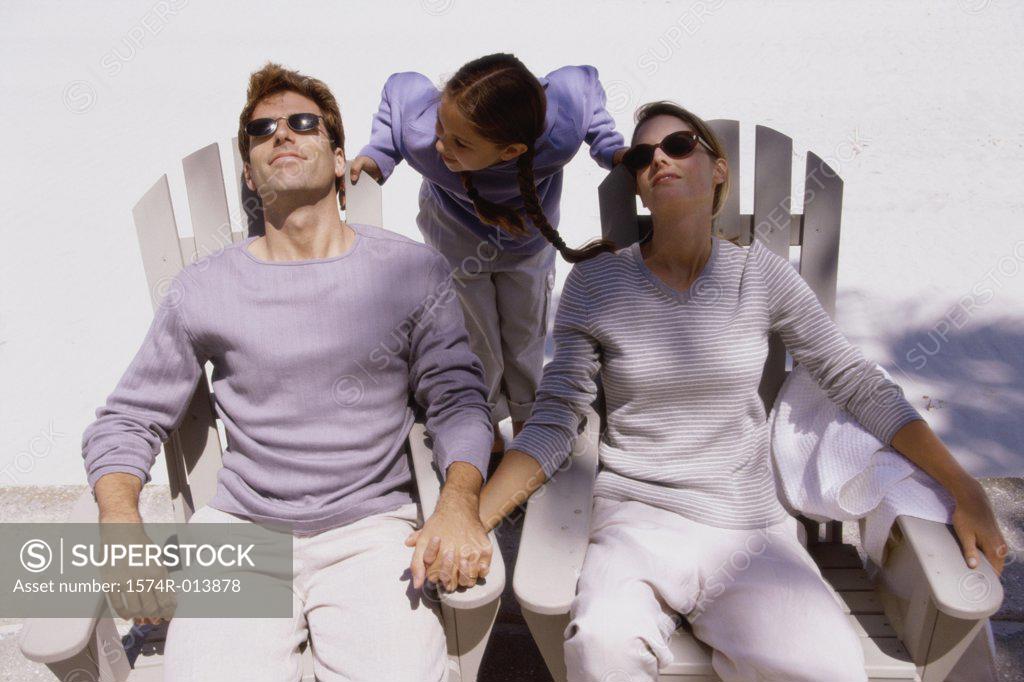 Stock Photo: 1574R-013878 Parents sitting in chairs with their daughter standing behind them