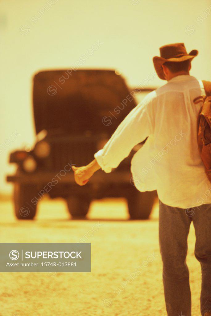 Stock Photo: 1574R-013881 Rear view of a young man hitchhiking