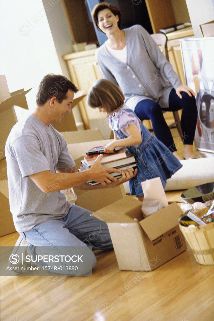 Stock Photo: 1574R-013890 Father and daughter packing books in a cardboard box