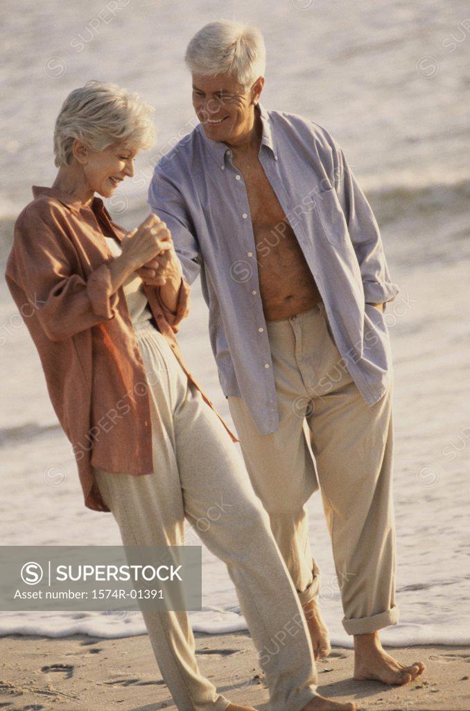 Stock Photo: 1574R-01391 Senior couple walking on the beach