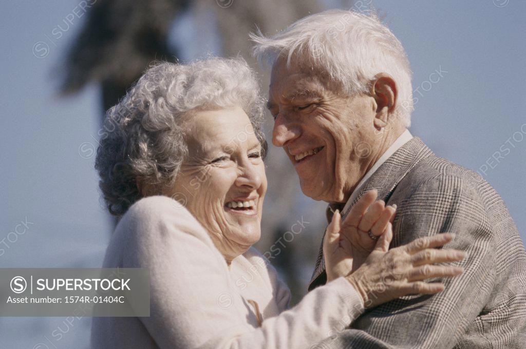 Stock Photo: 1574R-01404C Senior couple standing together laughing