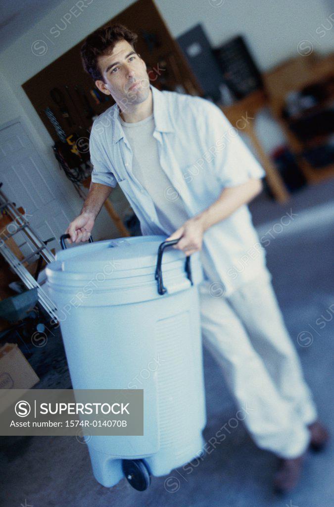 Stock Photo: 1574R-014070B High angle view of a young man carrying a trash can