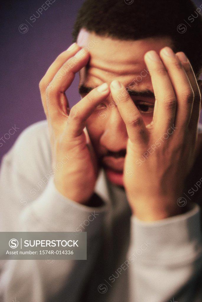 Stock Photo: 1574R-014336 Close-up of a young man covering his face with his hands