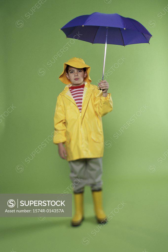 Stock Photo: 1574R-014357A Portrait of a boy wearing a raincoat holding an umbrella