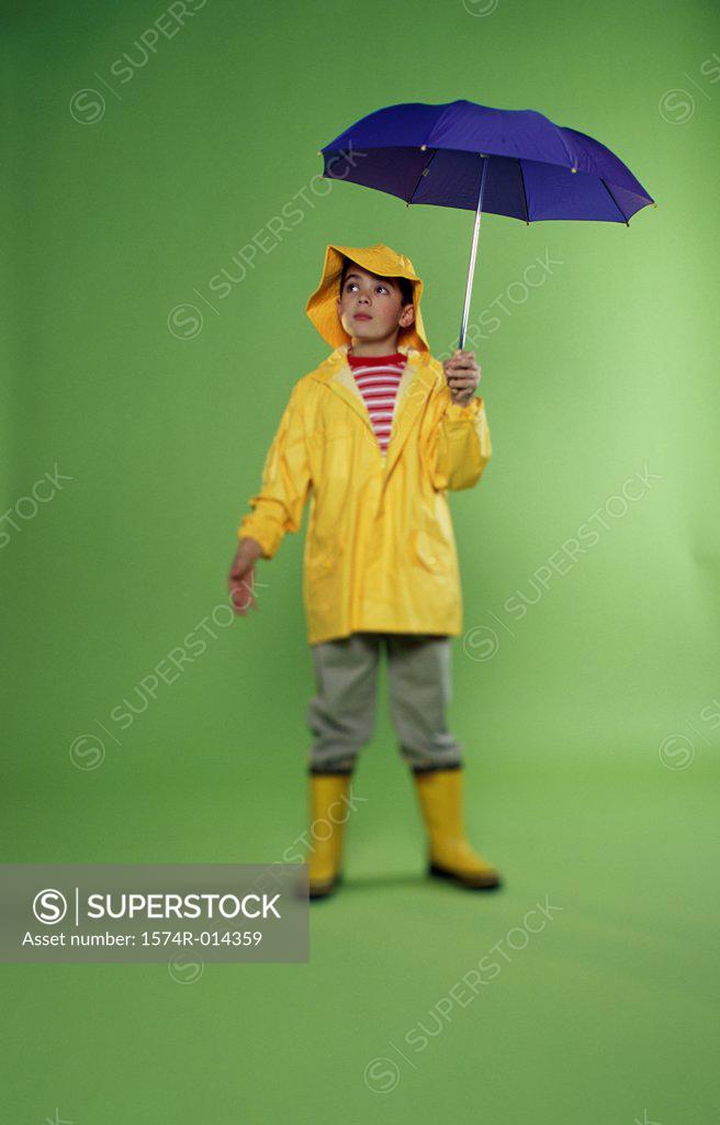 Stock Photo: 1574R-014359 Boy wearing a raincoat and holding an umbrella