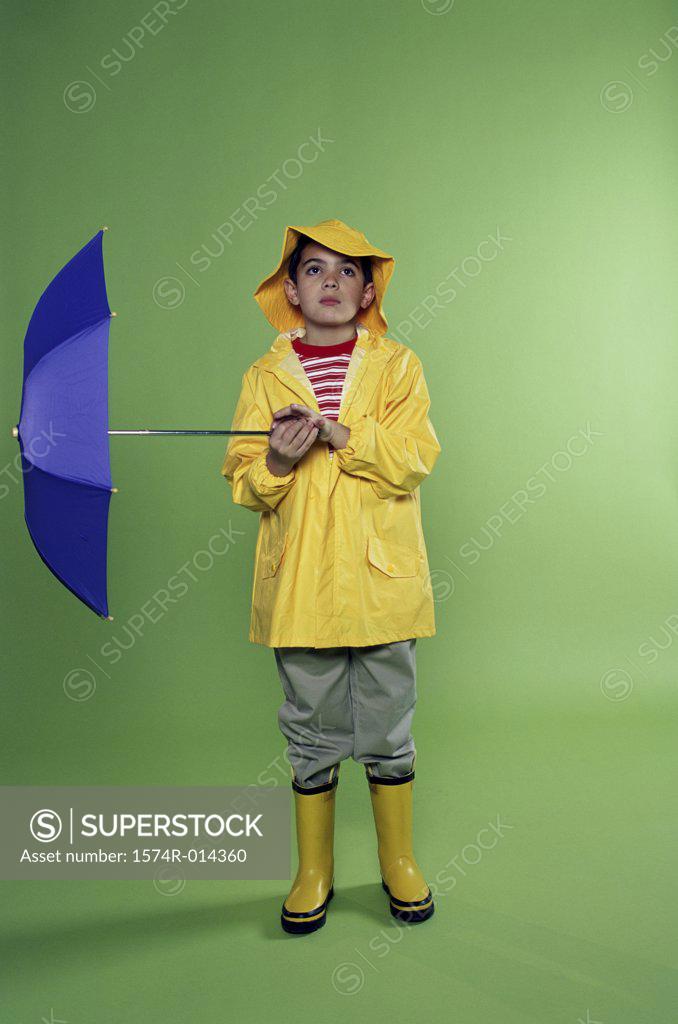 Stock Photo: 1574R-014360 Boy wearing a raincoat and holding an umbrella