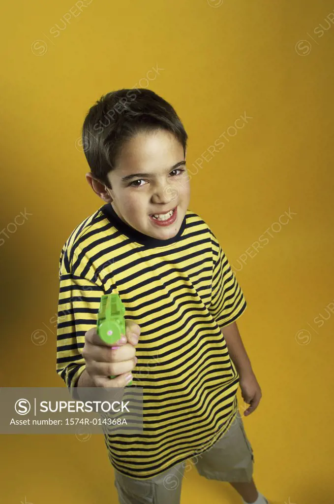 Portrait of a boy holding a toy gun
