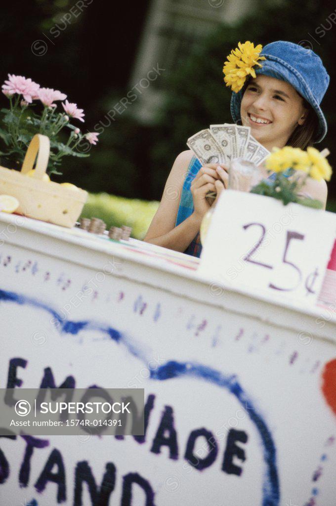Stock Photo: 1574R-014391 Girl making money at a lemonade stand