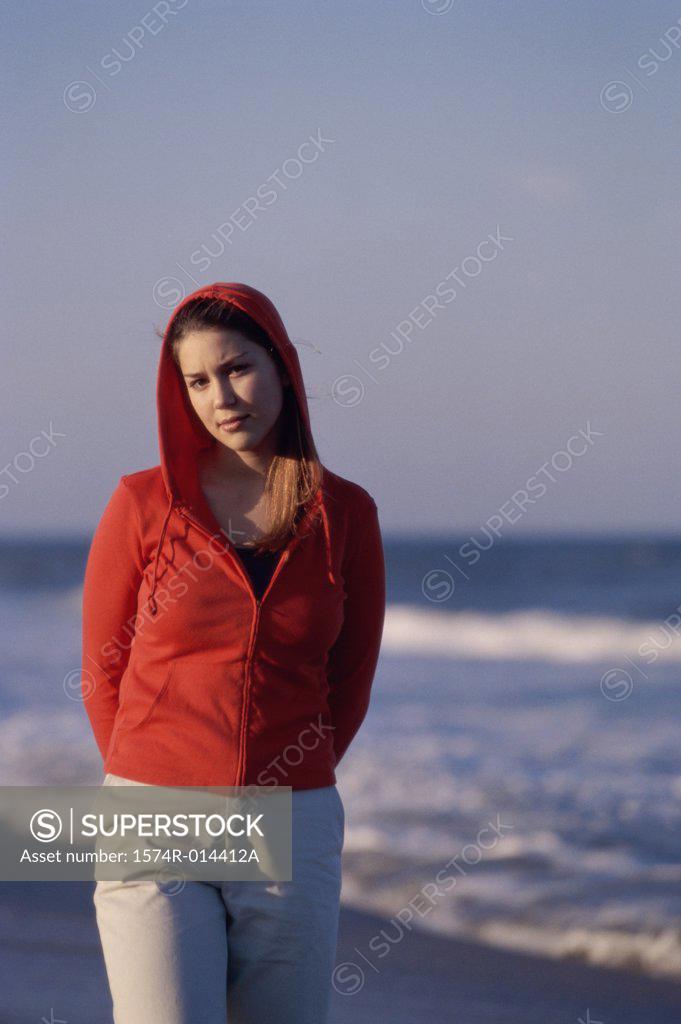 Stock Photo: 1574R-014412A Portrait of a teenage girl wearing a hooded shirt on the beach