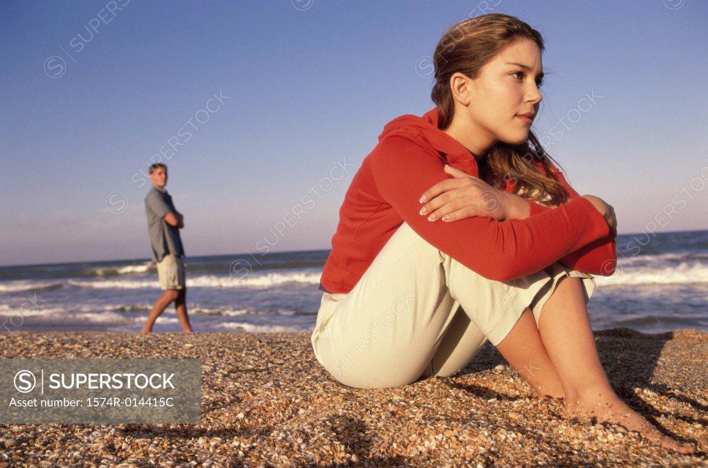 Stock Photo: 1574R-014415C Side profile of a teenage girl sitting on the beach