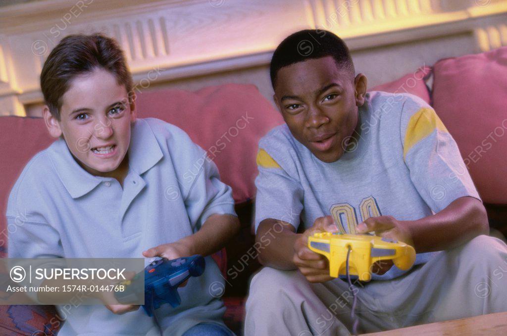 Stock Photo: 1574R-014476B Portrait of two teenage boys playing video games