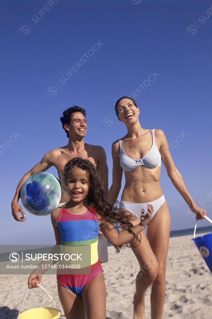 Stock Photo: 1574R-014480B Low angle view of parents and their daughter standing on the beach