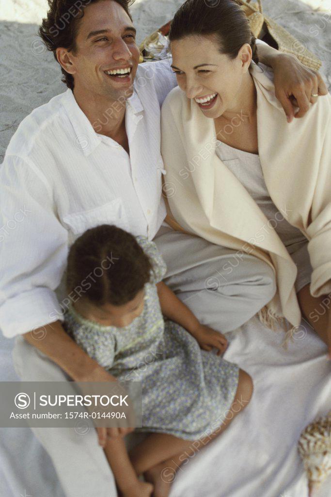 Stock Photo: 1574R-014490A High angle view of parents and their daughter laughing on the beach